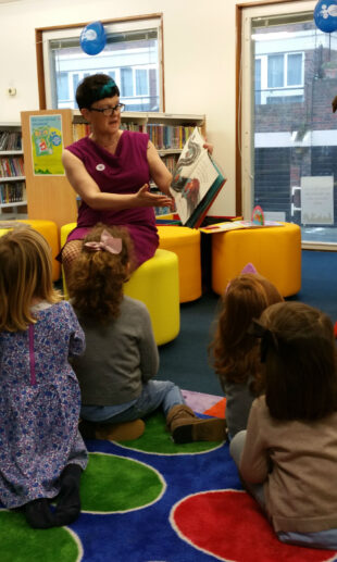 Baroness Neville Rolfe reading to children in Northcote library.