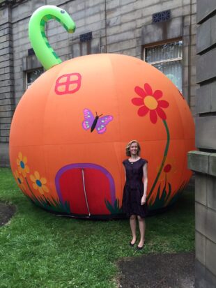 Kathy with the giant peach which stood outside Barrow library during the Summer Reading Challenge. Photo credit: Cumbria libraries