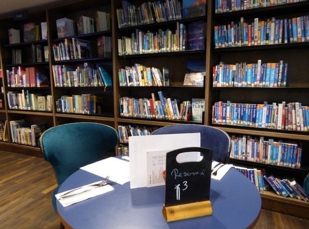 Cafe tables among the shelves at Storyhouse.