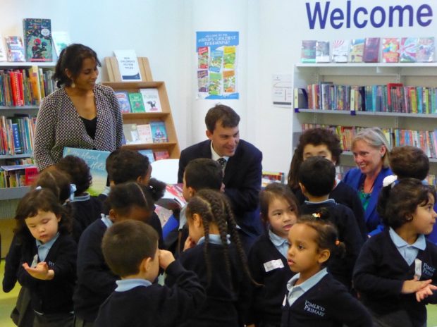 John Glen surrounded by children in Pimlico library. Also just visible are (on the right) author Smriti Prasadam Halls, and on the left, Cllr Jacqui Wilkinson, deputy Cabinet Member for environment and community services, at Westminster Council.