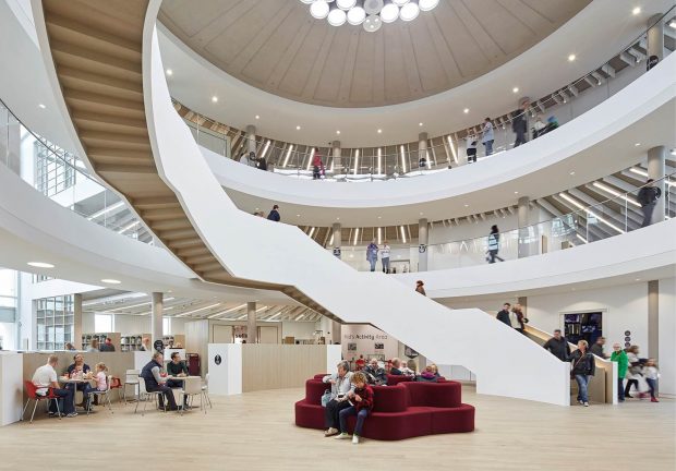 Photo of the inside of a library with a big winding staircase in the centre