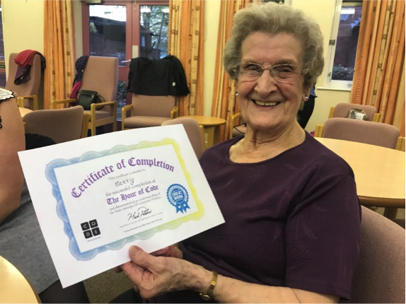 Photo of an older woman holding her certificate