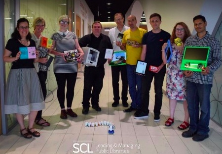 Photo of a group of people all holding a piece of digital equipment