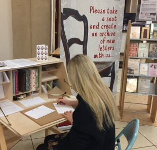 A woman sitting at a desk and writing a letter