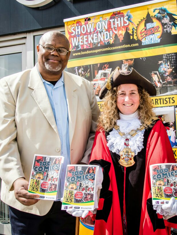 Photo of a man and a woman holding flyers for the comics event