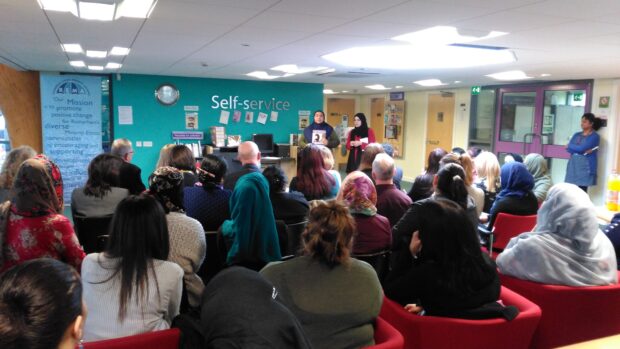 Group of people sitting in a library for a presentation.