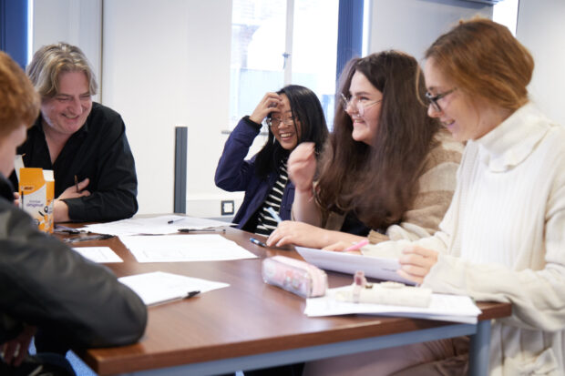 Photo of a group of young people sitting around a table.