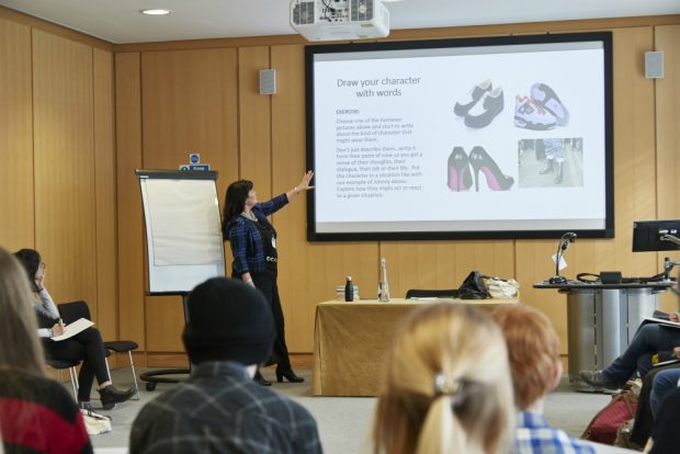 Photo of a woman presenting to a room of people
