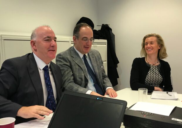 Photo of 2 men and a woman sitting at a table