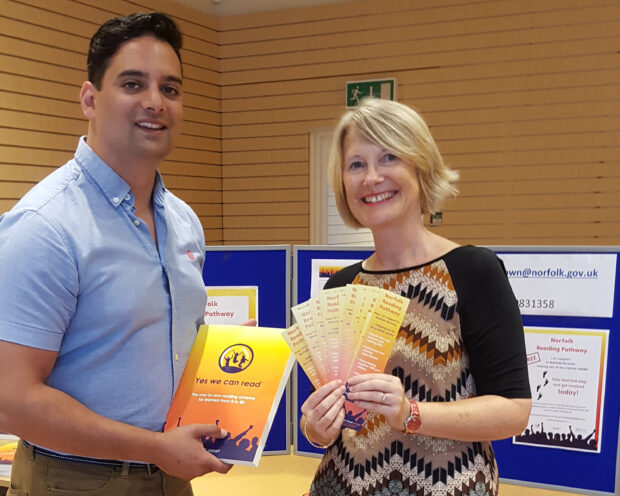 Photo of 2 people holding Norfolk Reading Pathway literature at one of Norfolk‘s pop-up shops.