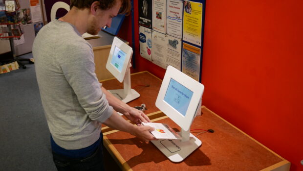 Photo of a man scanning an item to return it in the library