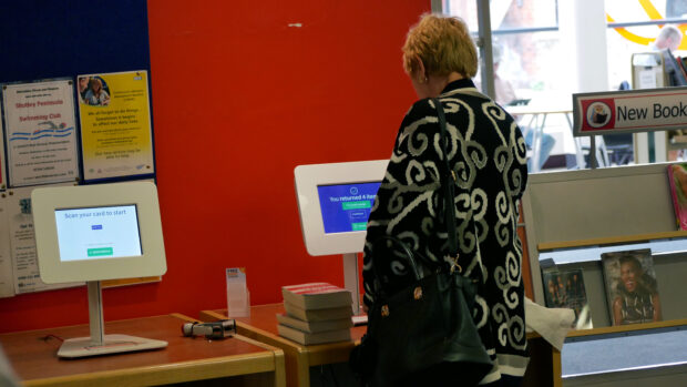 Photo of a women returning books in a library