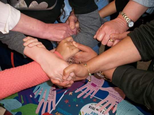 Photo of people holding hands as part of the friendship project in Sheffield.