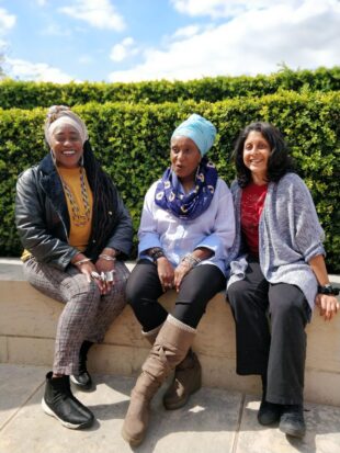 Photo of 3 poets sitting outside. 