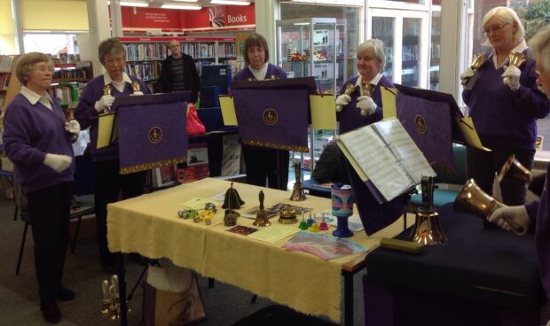 Photo of people bell ringing in a library