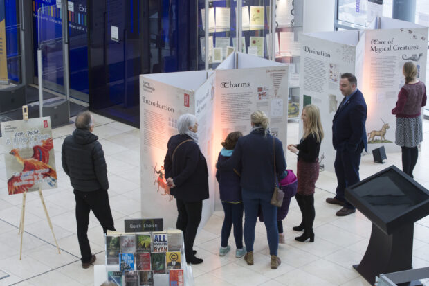 Photo of visitors in Newcastle central library looking at exhibition boards.