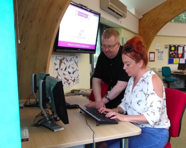 Photo of Stephen helping a woman get online in Mowbray Gardens library.