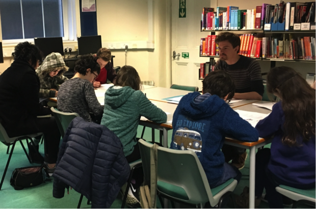 Photo of Alan delivering a workshop to teenagers in a temporary library building.