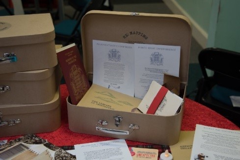 Photo of an open suitcase with various documents in and around it.