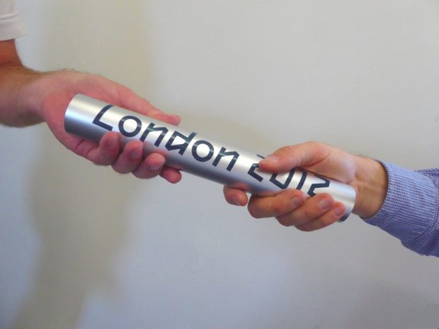 Photo of 2 people passing a London 2012 baton