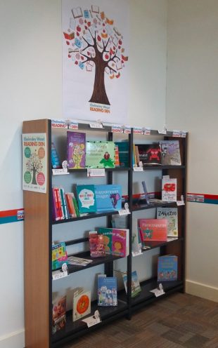 Photo of a bookshelf with books from the Reading den collection on them.