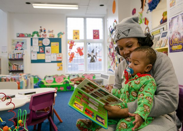 Photo of a mother reading with her child in a library