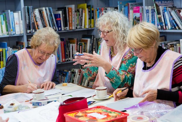 Photo of 3 ladies round a table doing arts and crafts, in a library