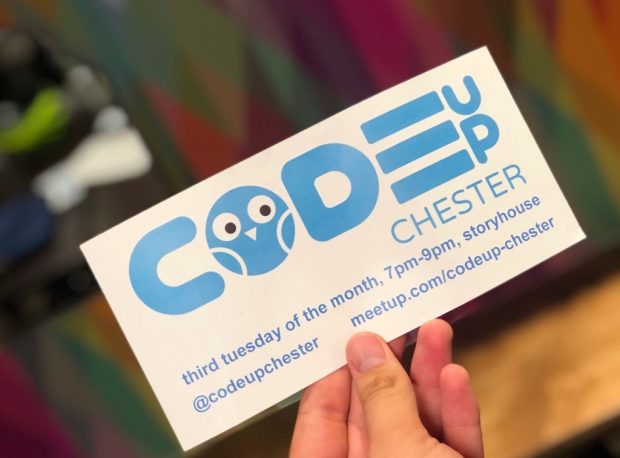 Hand holding a card promoting codeup Chester events - the letter o in the log is in the shape of an owl