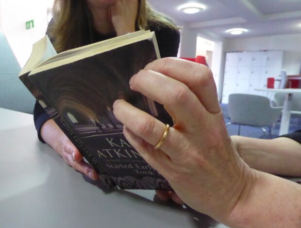 2 people, reading a book together