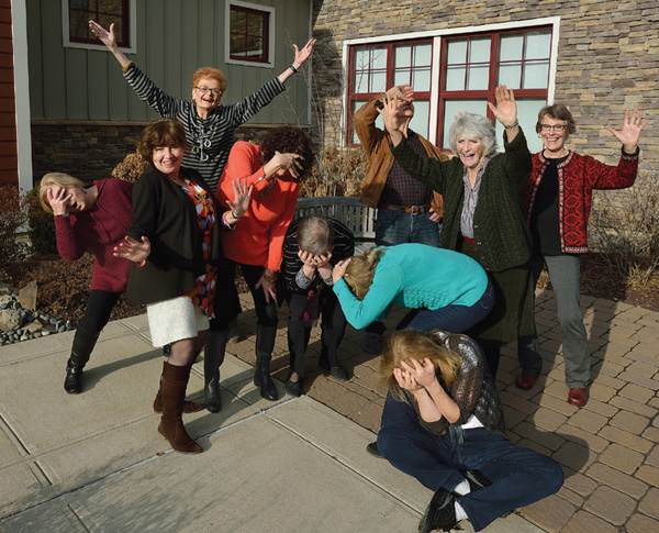 Photo of a group of women outside a stone building striking dramatic poses