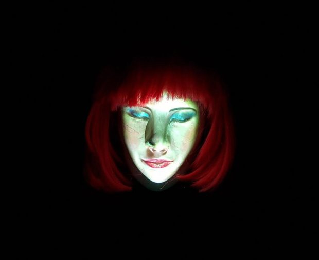 Photo of a red headed woman against a black background