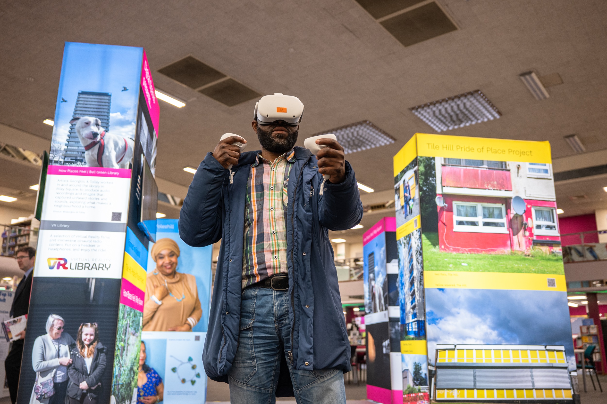 MAn wearing virtual reality goggles standing in front of digital exhibition